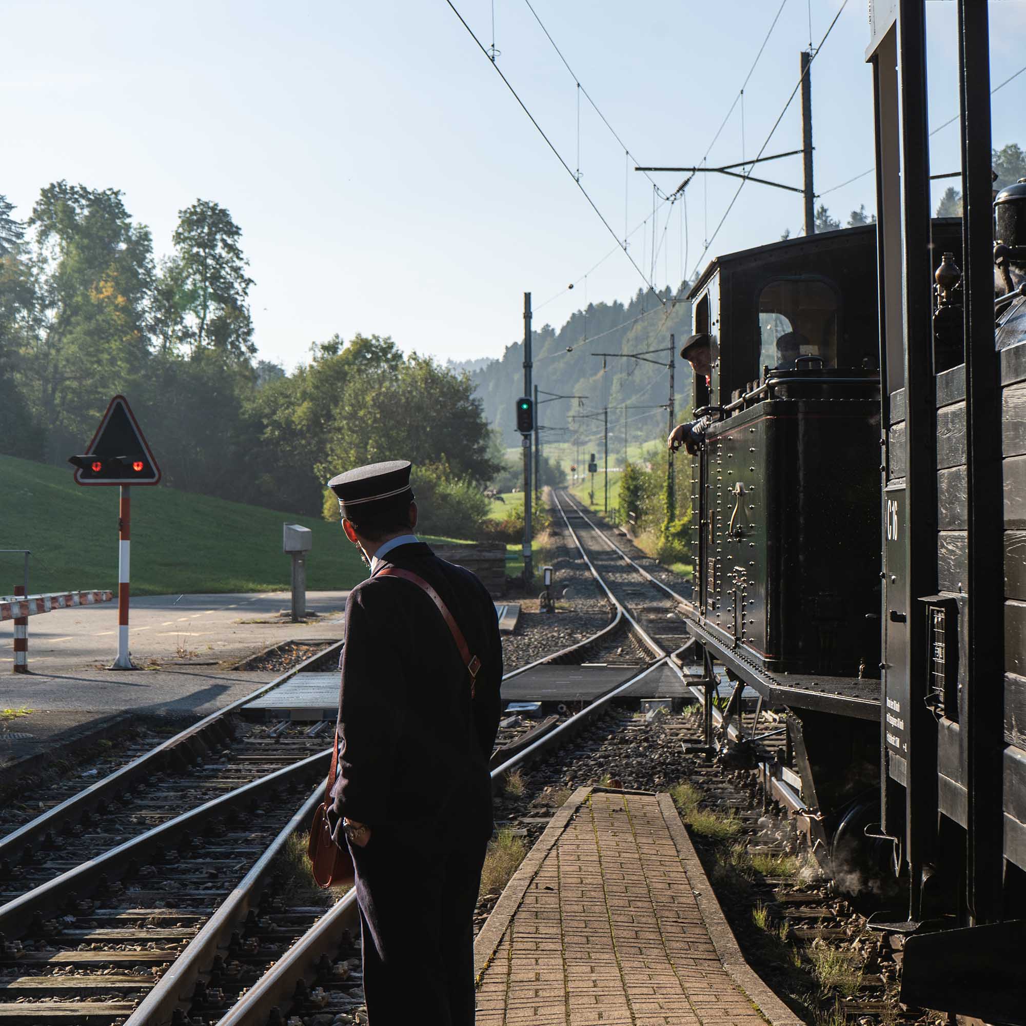 Dampfzug der Emmentalbahn abfahrbereit im Bahnhof Dürrenroth mit Zugchef und Dampflokführer